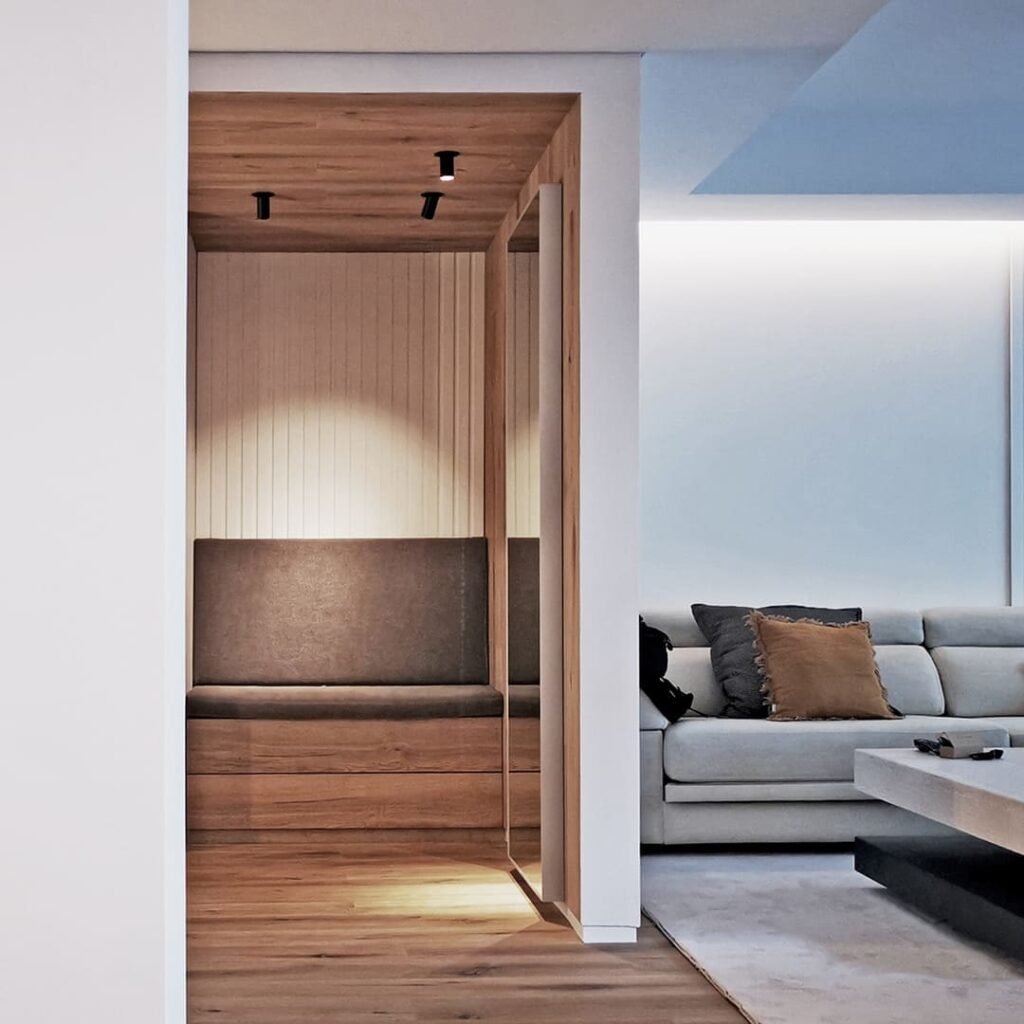 Sala de estar junto a recibidor con diseño elegante, luz natural e integración espacial, obra de estudio de arquitectura en Toledo.